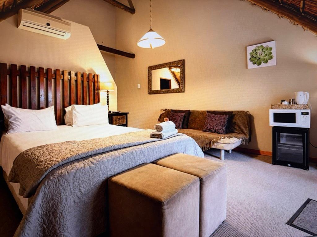 An air-conditioned bedroom with an ottoman bench at the foot of the bed