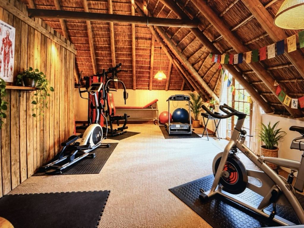 The guest gym, with exercise equipment under a thatched roof
